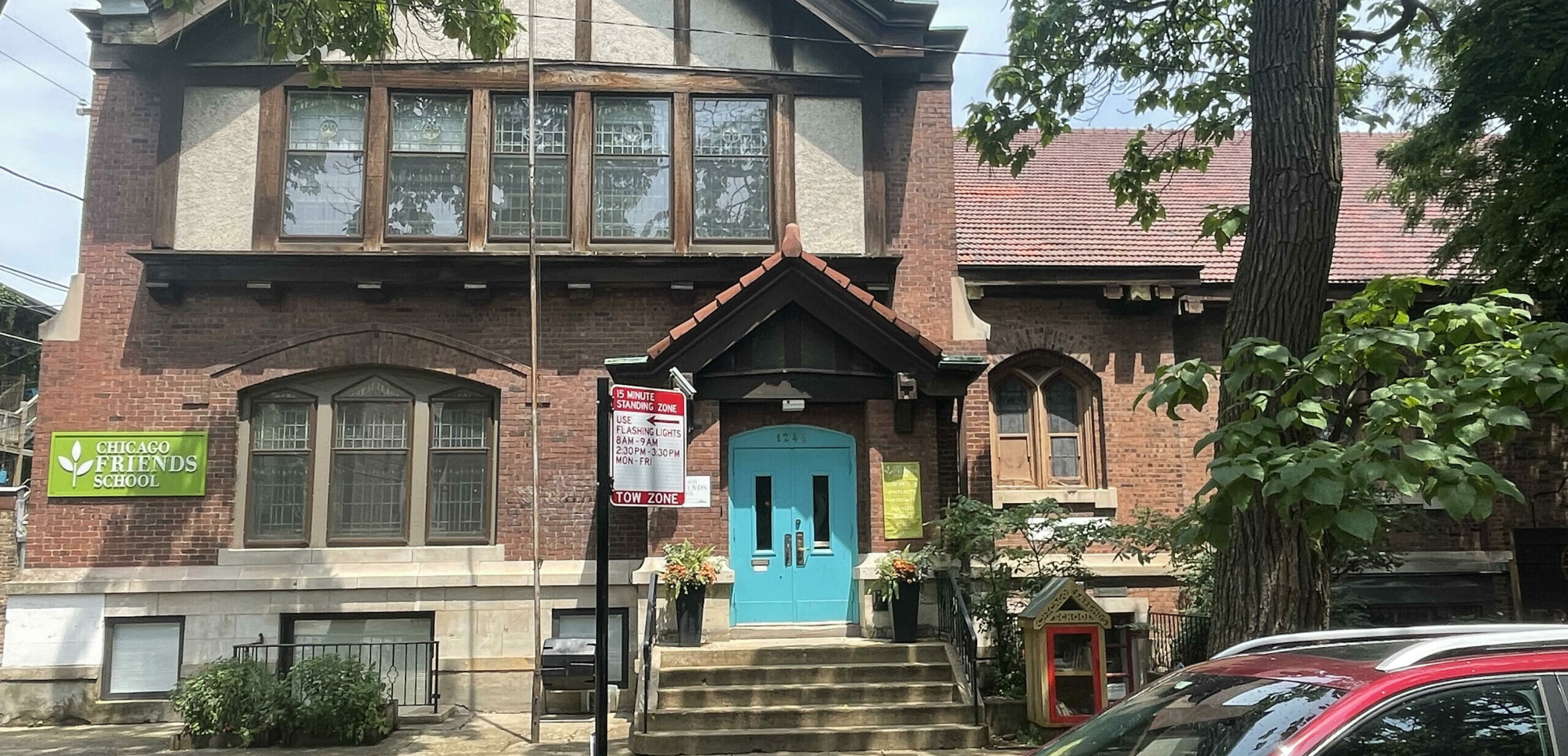 Front of a school building with stairs leading up to a turquoise door