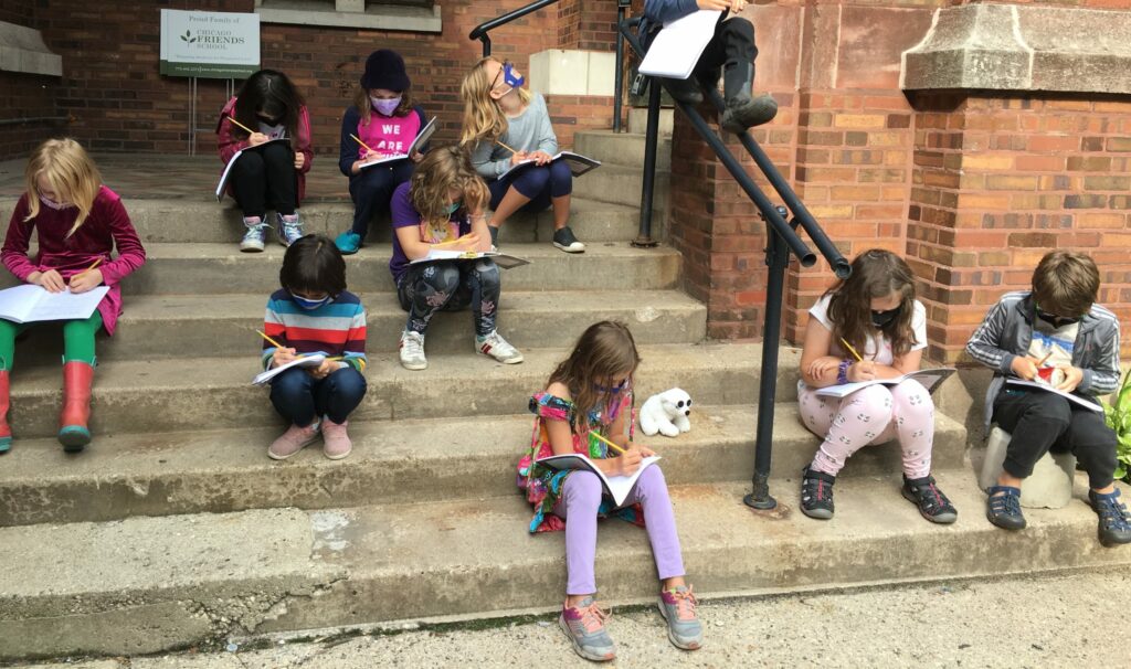 Students reading while sitting outside on school stairs