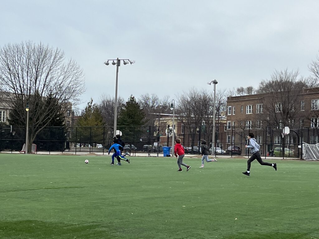 Children playing soccer on a large field